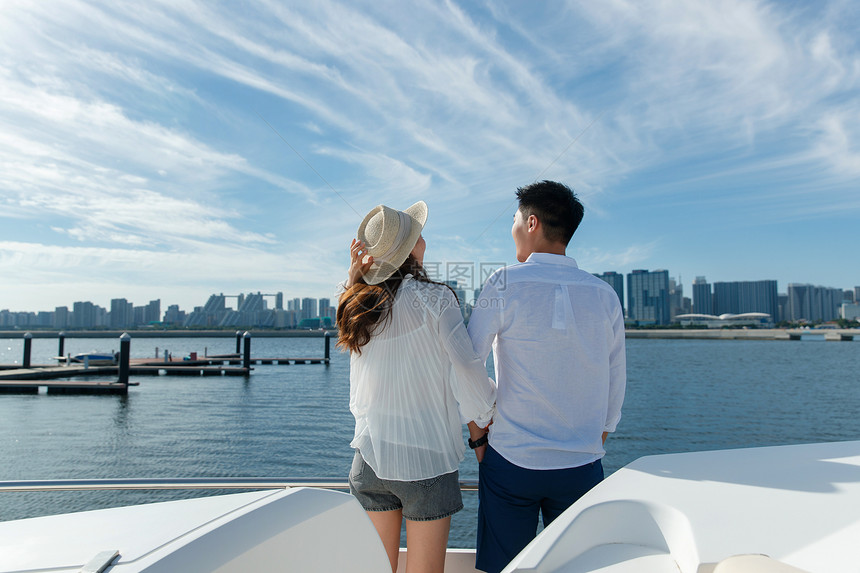 浪漫的青年夫妇站在游艇甲板上图片