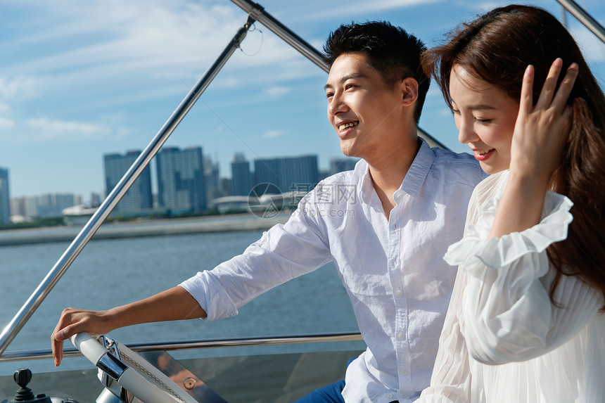 浪漫的青年夫妇驾驶游艇出海图片