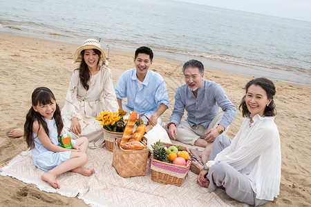 沙滩水果在海边度假的一家人野餐背景