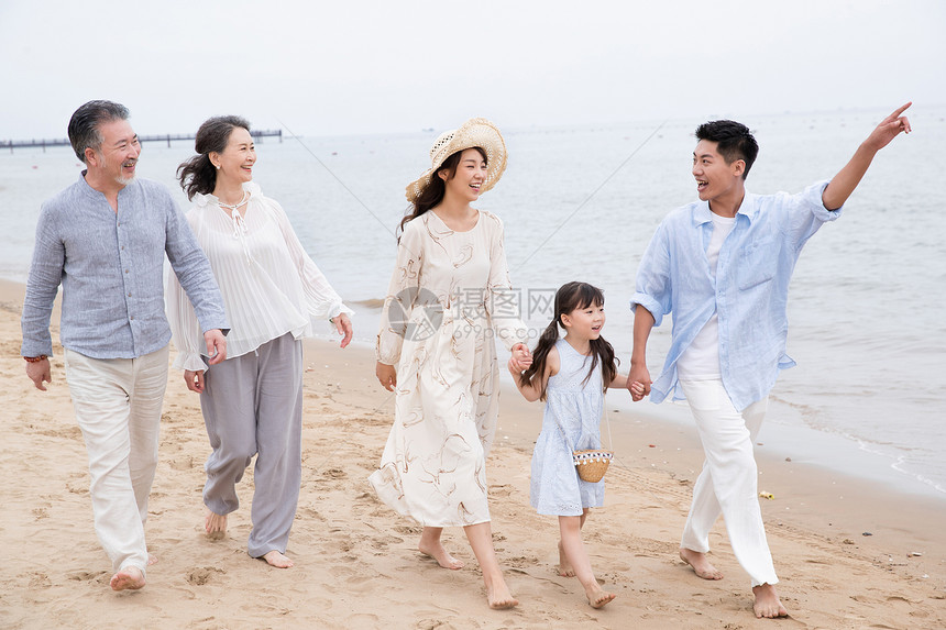 快乐的一家人在海滩上散步图片