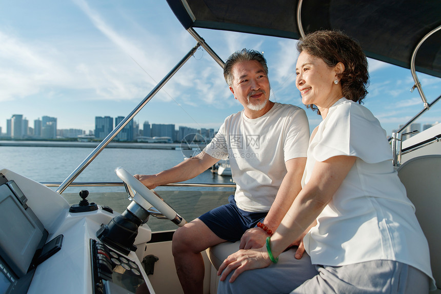 幸福的老年夫妇驾驶游艇出海图片