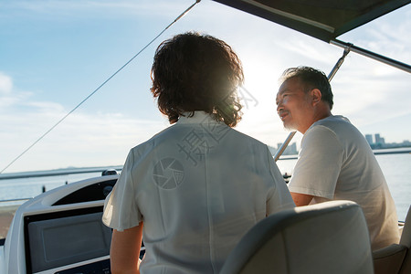 幸福的老年夫妇驾驶游艇出海高清图片