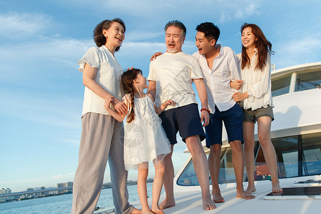 女孩在晒日光浴快乐的一家人站在游艇上背景