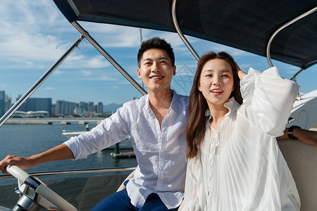 浪漫的青年夫妇乘坐游艇出海高清图片
