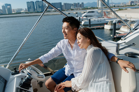 船的方向盘浪漫的青年夫妇乘坐游艇出海背景
