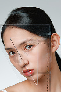 透明尺子素材做面部整形的青年女人拿着尺子背景