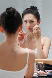 浴室仙人笔属年轻女人对着镜子化妆背景