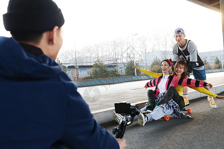 情侣溜冰玩滑板的年轻人背景