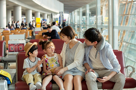 快乐家庭坐在机场候机厅图片