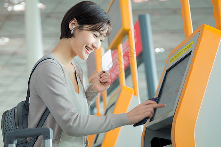 航空电子设备商务女士在机场使用自动售票机背景