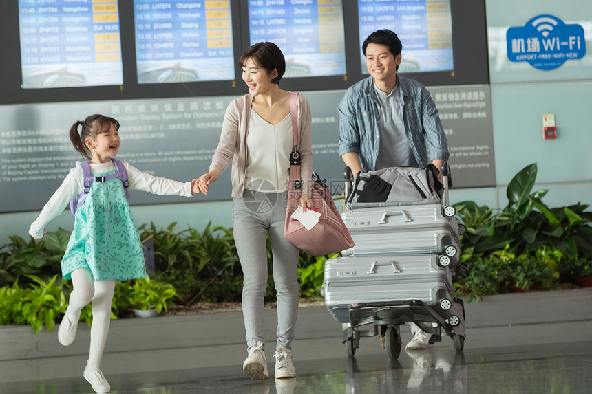快乐家庭在机场推着行李图片