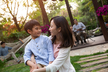 真的爱你妈妈和孩子在院子里玩耍背景