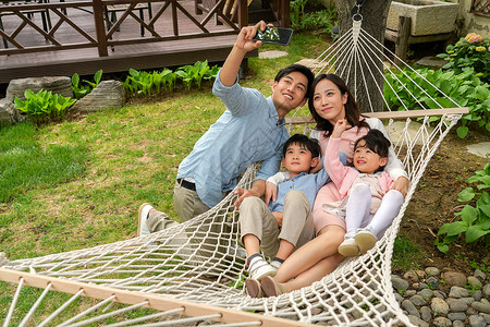 儿童吊床快乐家庭在院子里拍照背景