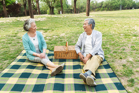 老年夫妇坐在公园草地上图片