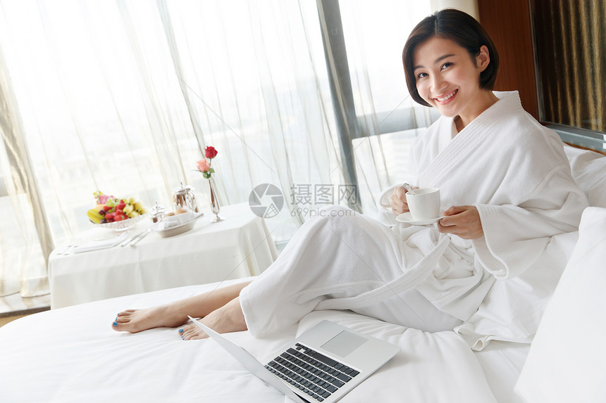 年轻女人在酒店房间里使用电脑图片