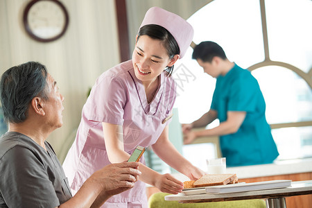 食堂工作人员护士照顾老年人用餐背景