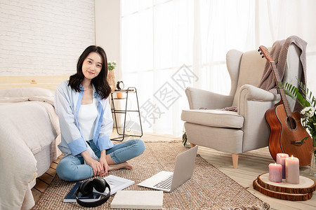 年轻的女青年坐在地毯上高清图片