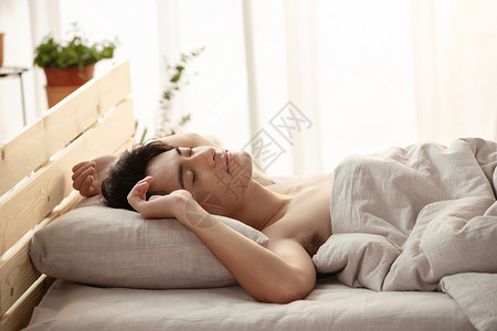 床上睡觉的年轻男人高清图片