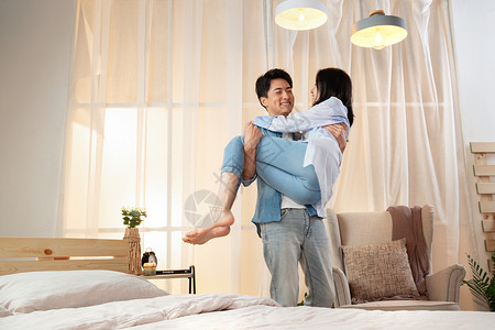 卧室里年轻丈夫把妻子抱了起来图片