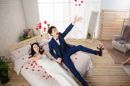 兴奋的新婚夫妇倒在床上高清图片