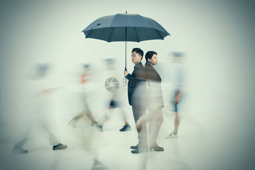 拿着雨伞的商务男女站在人群中图片