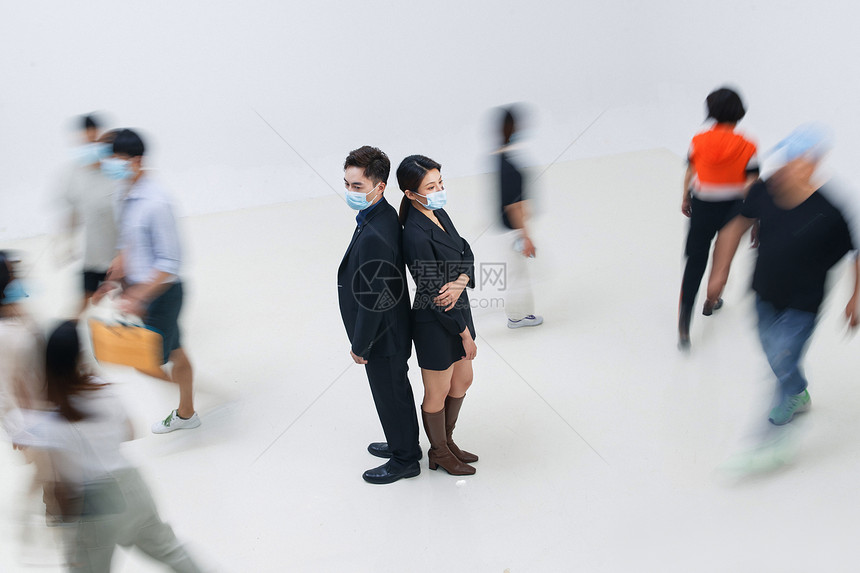 商务男女戴着口罩站在人群中图片
