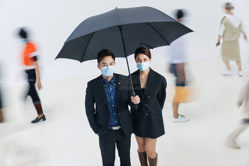 拿着雨伞的商务男女戴着口罩站在人群中图片