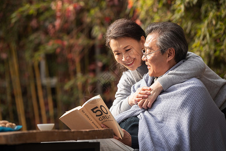 幸福的老年夫妇在户外看书高清图片