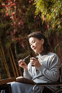 休闲看书晒太阳孤独的老年女人在院子里晒太阳背景