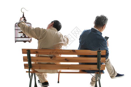 拿着鸟笼的老人和拿着手机的老人坐在长椅上图片