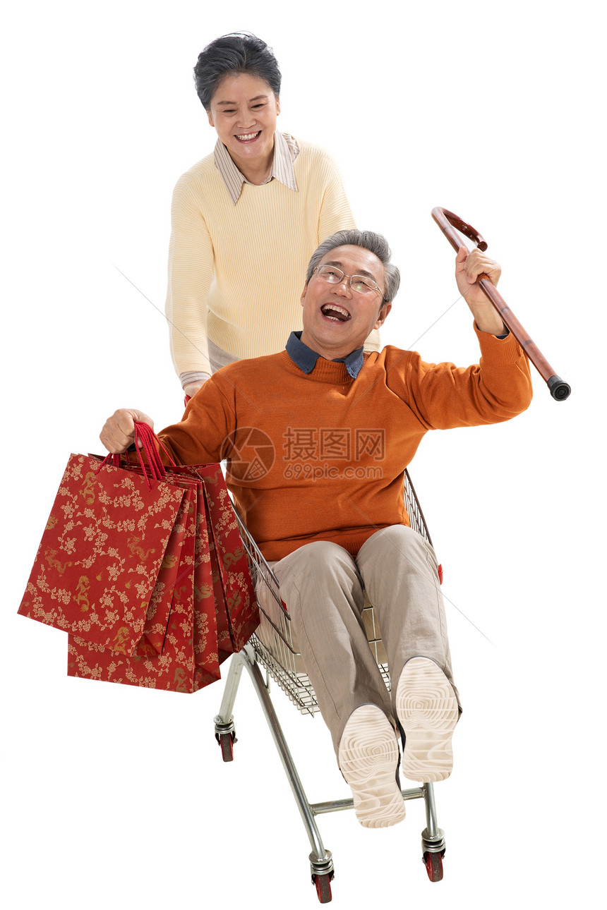 快乐老人推着坐在购物车里的老伴图片