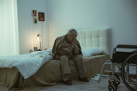 孤独的老人坐在床上图片