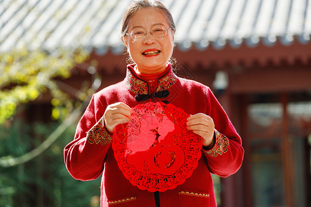 领结元素老年女人手拿窗花庆祝新年背景