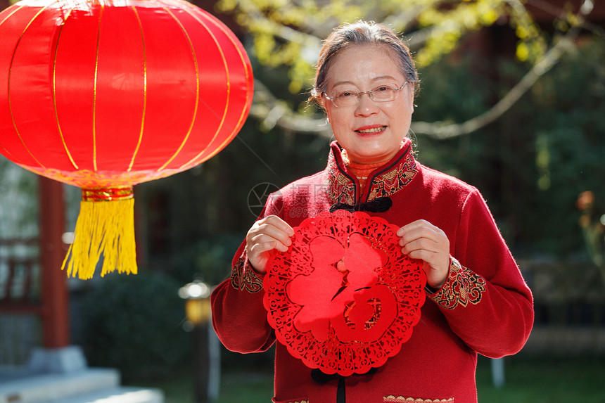 老年女人手拿窗花庆祝新年图片