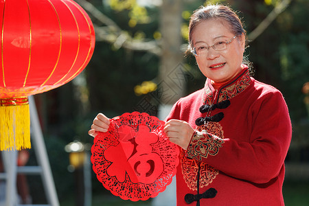 老年女人手拿窗花庆祝新年图片