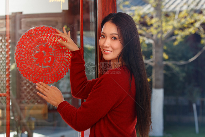 年轻女人过年贴窗花图片