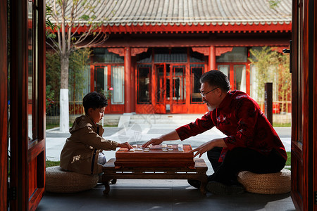 智慧物联祖孙俩在庭院里下象棋背景