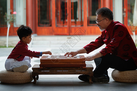 下象棋男人祖孙俩在庭院里下象棋背景