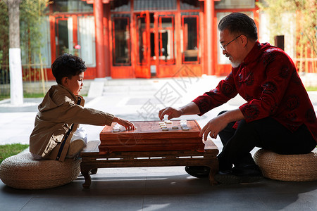 祖孙俩在庭院里下象棋高清图片