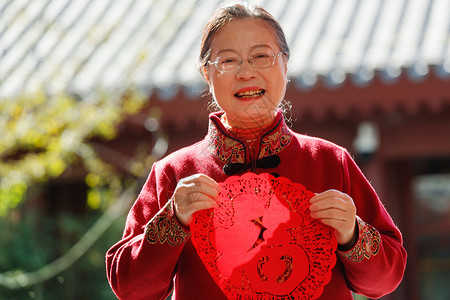 老年女人手拿窗花庆祝新年图片