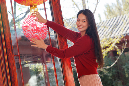 年轻女人过年贴窗花图片