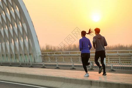 公路上奔跑运动员青年情侣户外慢跑背景