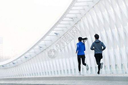 公路上奔跑运动员青年情侣户外慢跑背景