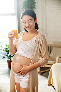 轻松的大生意孕妇正在喝果汁背景