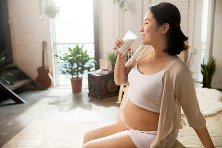 侧面视角20多岁孕妇正在喝牛奶背景