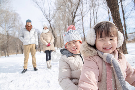 冬季玩雪女孩欢乐家庭在雪地上玩雪橇背景