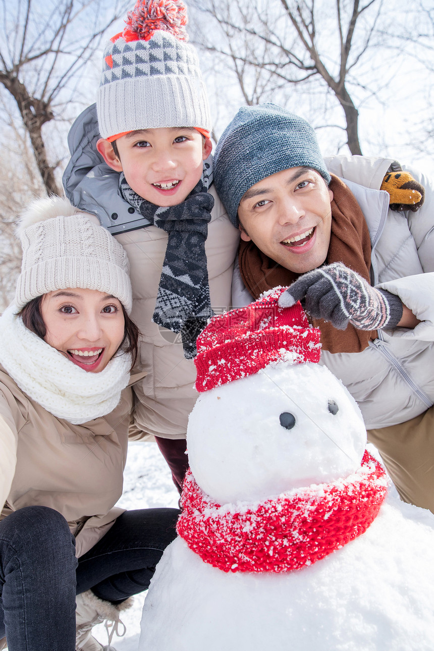 一家三口在雪地里堆雪人图片