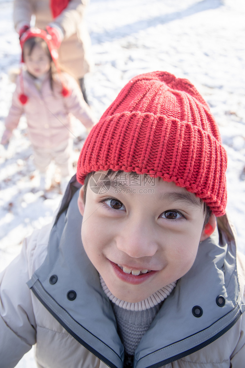 小男孩在雪地里玩耍图片