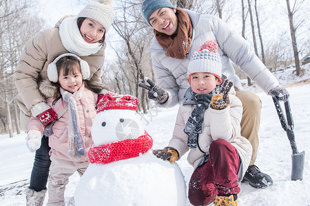 欢乐家庭在雪地里堆雪人图片