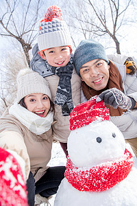 一家三口在雪地里堆雪人图片